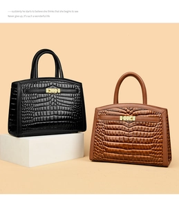 Detail of elegant crocodile-embossed handbags in black and brown with metal locks