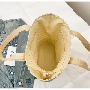 Detail view of woven beach tote showing spacious interior lining and secure zipper closure