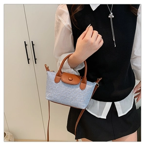 Detail of blue and white woven texture with brown leather strap and metal buckle