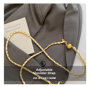 Detail of white leather woven chain strap with adjustable gold sphere metal buckle