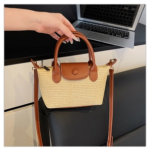 Detail of a mini woven tote bag with brown leather flap and handle for summer