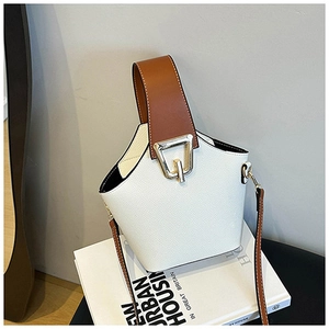 Detail of white lychee grain bucket bag with brown handle and golden metal buckle