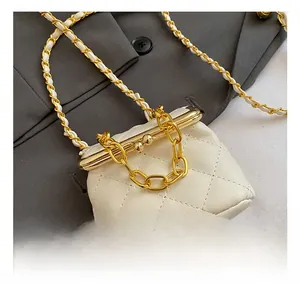 Detail of the ivory quilted mini bag with gold chain strap and elegant metal clasp