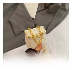 Detail of white quilted mini chain bag with vintage gold metal frame closure