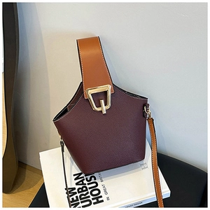 Macro detail of dark brown pebble leather bucket bag with golden metal hardware buckle