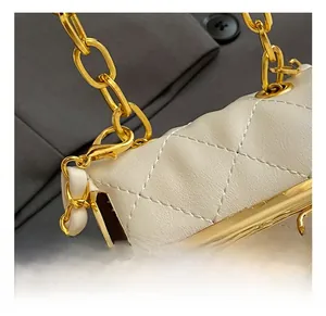 Detail of white quilted bag showing the golden metal chain and high-quality spring hook