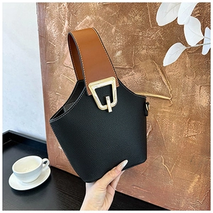 Detail of minimalist bucket bag showing lychee grain leather and gold buckle