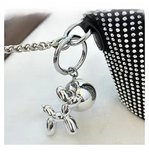 Dettaglio macro di un ciondolo a forma di cane palloncino argento con strass lucidi