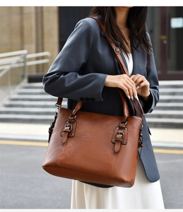 Gros plan sur le sac fourre-tout marron avec boucles en métal et texture cuir grainé