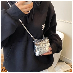 Close-up of silver quilted mini crossbody bag with metal chain strap and sleek lock