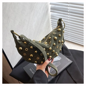Detail of dark green suede handbag featuring golden rivets and metallic eyelets on side