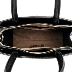 Top view of black leather handbag interior with brown logo lining and gold zipper pocket