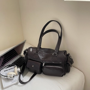 Sac bandoulière vintage marron avec texture litchi à côté d'un ordinateur et d'un casque