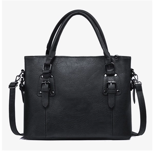 Détail d'un grand sac cabas noir en cuir grainé avec bandoulière réglable amovible