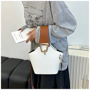 Detail of lychee pattern leather texture and gold metal hardware on contrast bucket bag