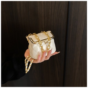 Detail of a mini quilted chain bag in cream white with a vintage gold frame clasp