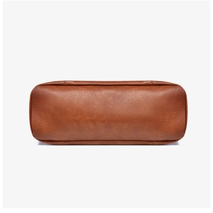 Détail de la texture en cuir marron et des coutures sur le fond du sac fourre-tout