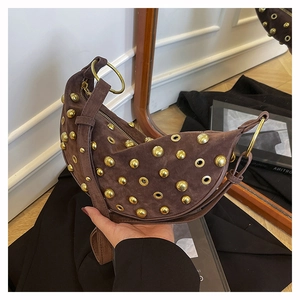 Close-up of brown suede moon bag featuring gold rivets and vintage metallic eyelets