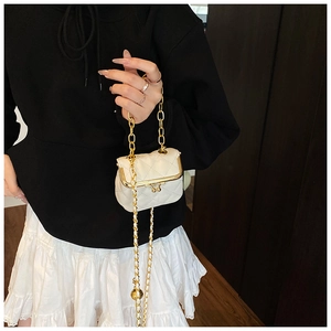 Detailed view of white quilted mini crossbody bag with gold chain and kiss-lock closure