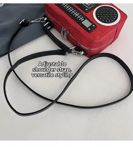 Detail of adjustable black shoulder strap on creative red glitter radio shape bag