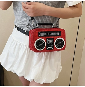 Macro shot of a red glittery radio shaped crossbody bag with vintage radio details