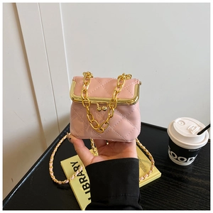 Detail of pink quilted mini bag featuring a chunky gold chain and vintage metal clasp