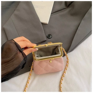 Detail of pink quilted mini bag showing gold metal clasp and herringbone fabric lining