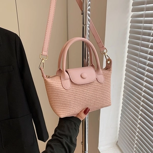 Pink hand-woven mini tote bag with leather handles and adjustable shoulder strap