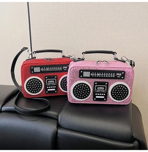 Close-up of red and pink retro radio-shaped handbags with sparkling sequin finish and straps