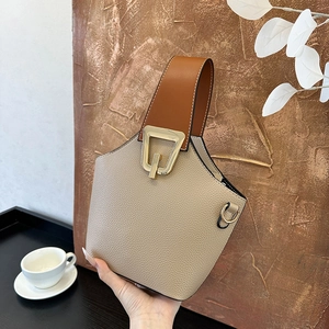 Beige pebbled leather bucket bag with caramel handle and gold geometric hardware buckle
