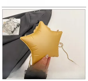 Macro shot of stylish yellow star-shaped bag with puffy pleated texture and gold chain