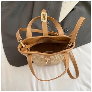 Close-up of woven bucket bag featuring gold hardware lock and internal zipper pocket