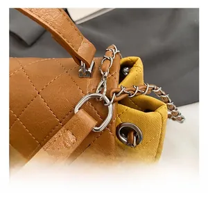 Detailed close-up of brown quilted stitching pattern and silver chain hardware on the bag