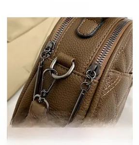 Detail of dark brown lychee leather texture and gunmetal gray zipper hardware
