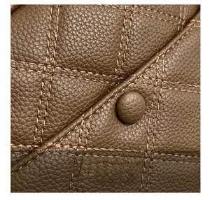 Close-up of brown quilted leather texture with diamond stitching and button detail