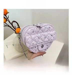 Détail du sac matelassé en cœur lavande avec cristaux et fermoir en camélia élégant