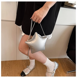 Detail of silver star-shaped crossbody bag with quilted metallic texture and chain strap