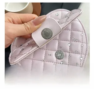 Gros plan d'un sac rose matelassé avec boucle magnétique en métal et détails de cristaux