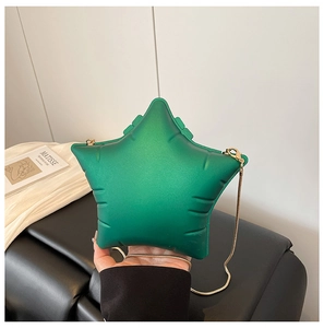 Detail of green star-shaped puffy crossbody bag with gold chain strap and fine stitching