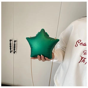 Detailed view of hand-held star-shaped green acrylic bag with elegant gold chain strap