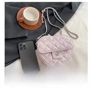 Détail du sac coeur rose matelassé avec cristaux et fermoir camélia en métal argent