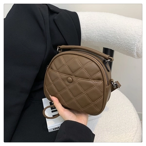 Detail of brown quilted pebbled leather crossbody bag with top handle and double zippers