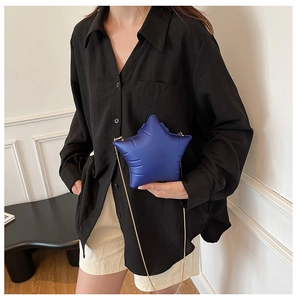 Detailed view of a navy blue star-shaped acrylic crossbody bag with gold chain strap