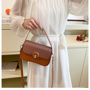 Détail d'un sac bandoulière marron vintage avec rabat tissé et fermoir métallique