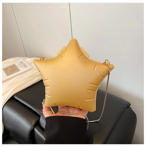 Detail of yellow star-shaped acrylic shoulder bag with embossed texture and gold chain strap