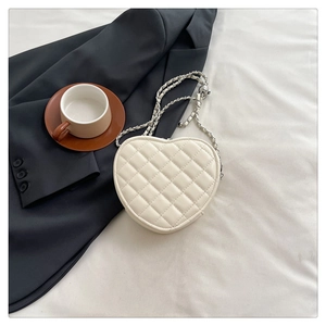 Détail du sac à bandoulière en cuir blanc en forme de cœur avec chaîne argentée