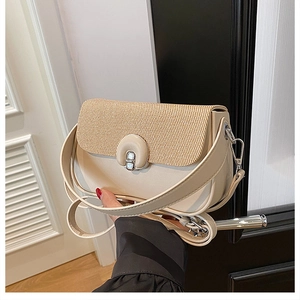 Détail du sac à bandoulière en similicuir blanc avec empiècement en paille et fermoir