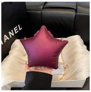 Detail of star-shaped purple acrylic clutch bag with delicate gold metal chain strap