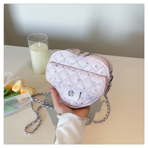 Détail du sac matelassé rose en forme de cœur avec strass et fermoir camélia argenté