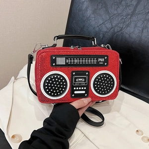 Creative red radio-shaped handbag with sparkly texture and vintage details shown on a model